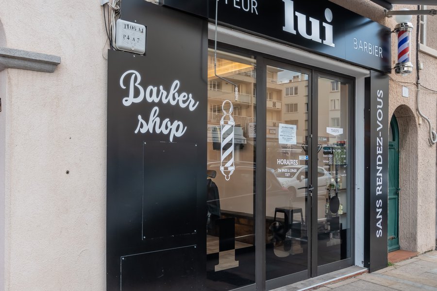 Devanture noire du salon Lui Coiffeur de Sainte-Maxime, inscription « Barbershop » et enseigne tournante